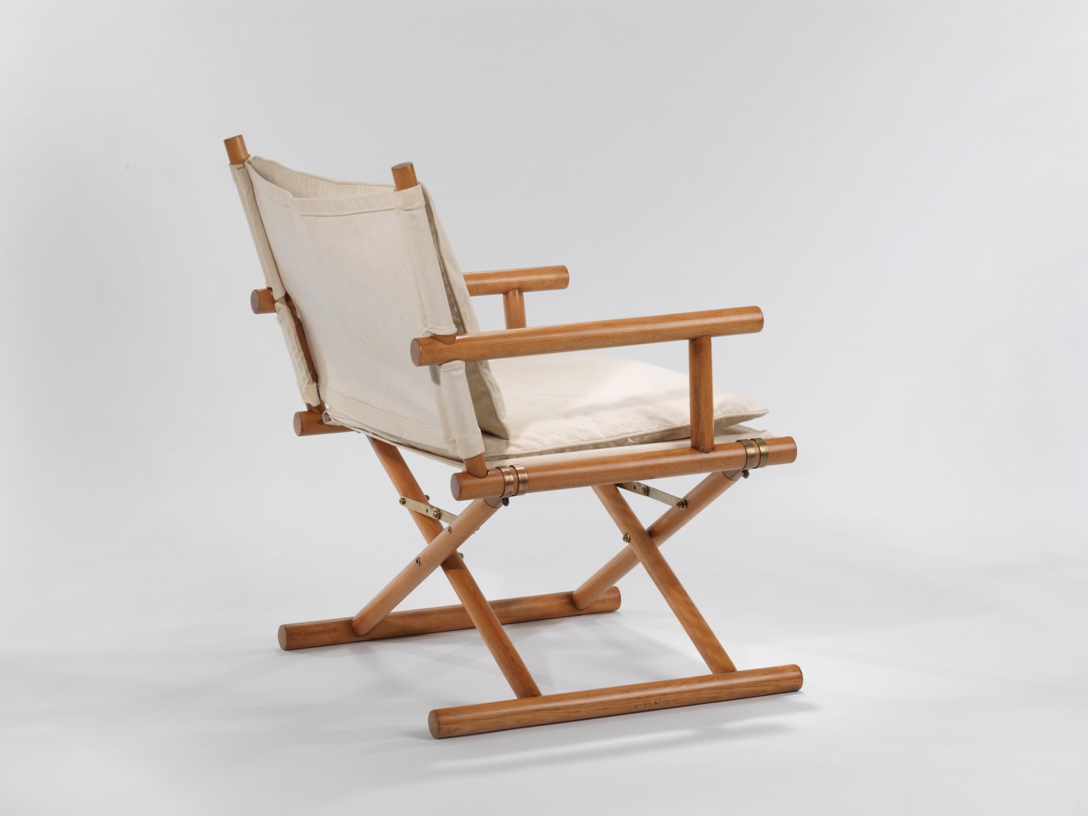 Wooden armchair with cotton upholstery in front of white background