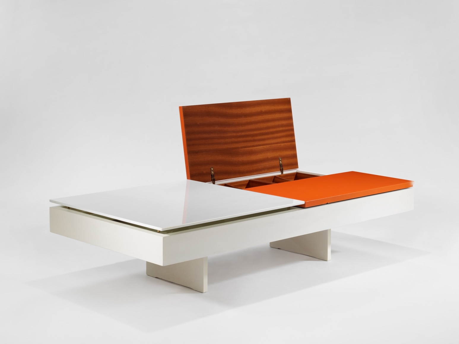 photograph of low table by Motte in a blank room, top of table is half orange and half white