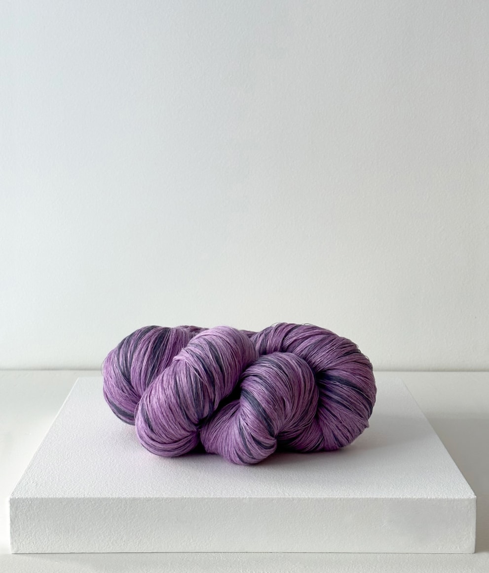 photograph of purple yarn-like linen braid in natural sunlight, in a white room