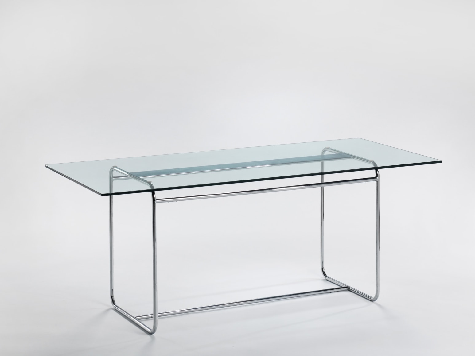 Arnal glass and metal dining table in an empty room