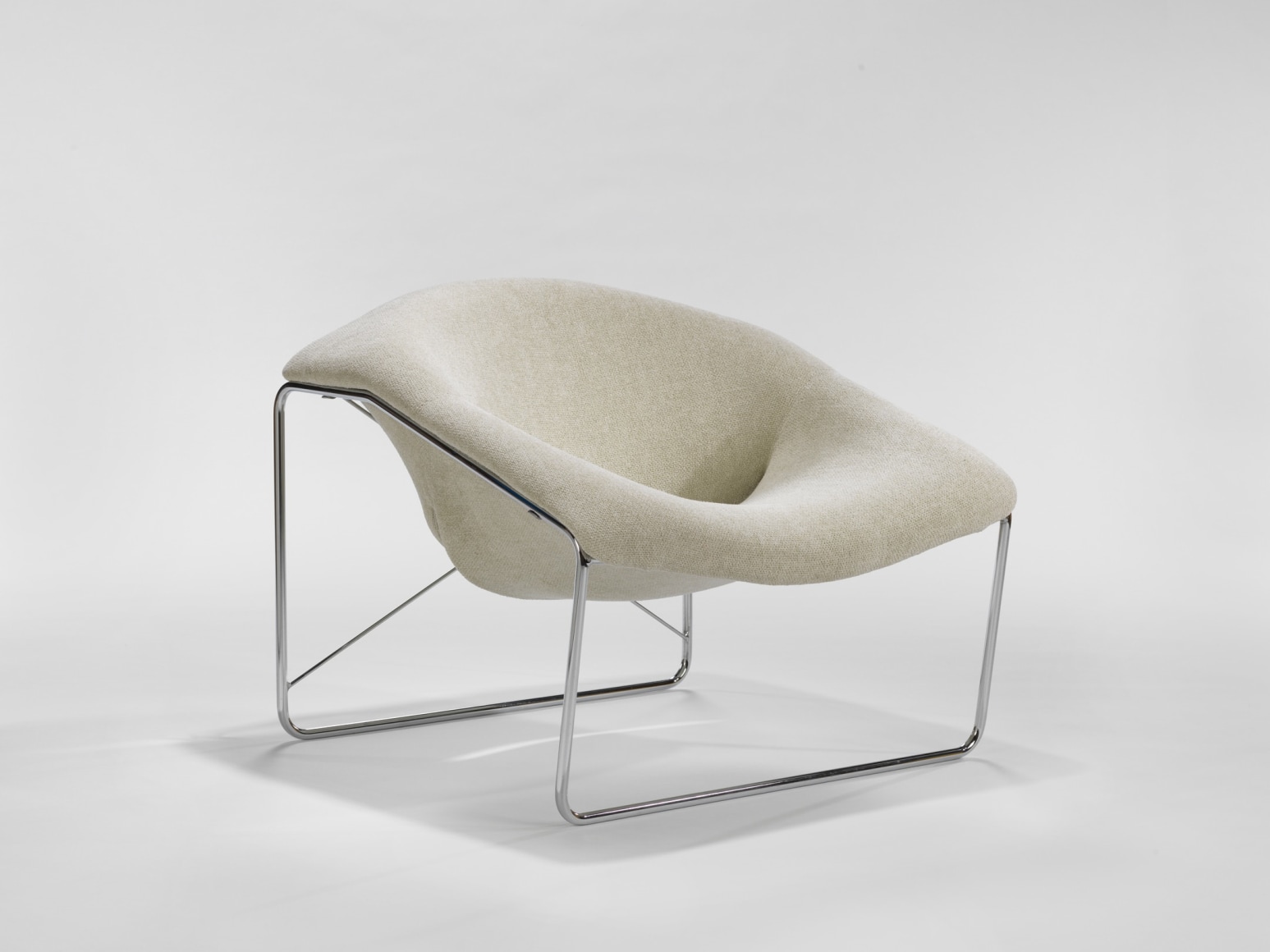 photograph of chair in a blank room with metal legs