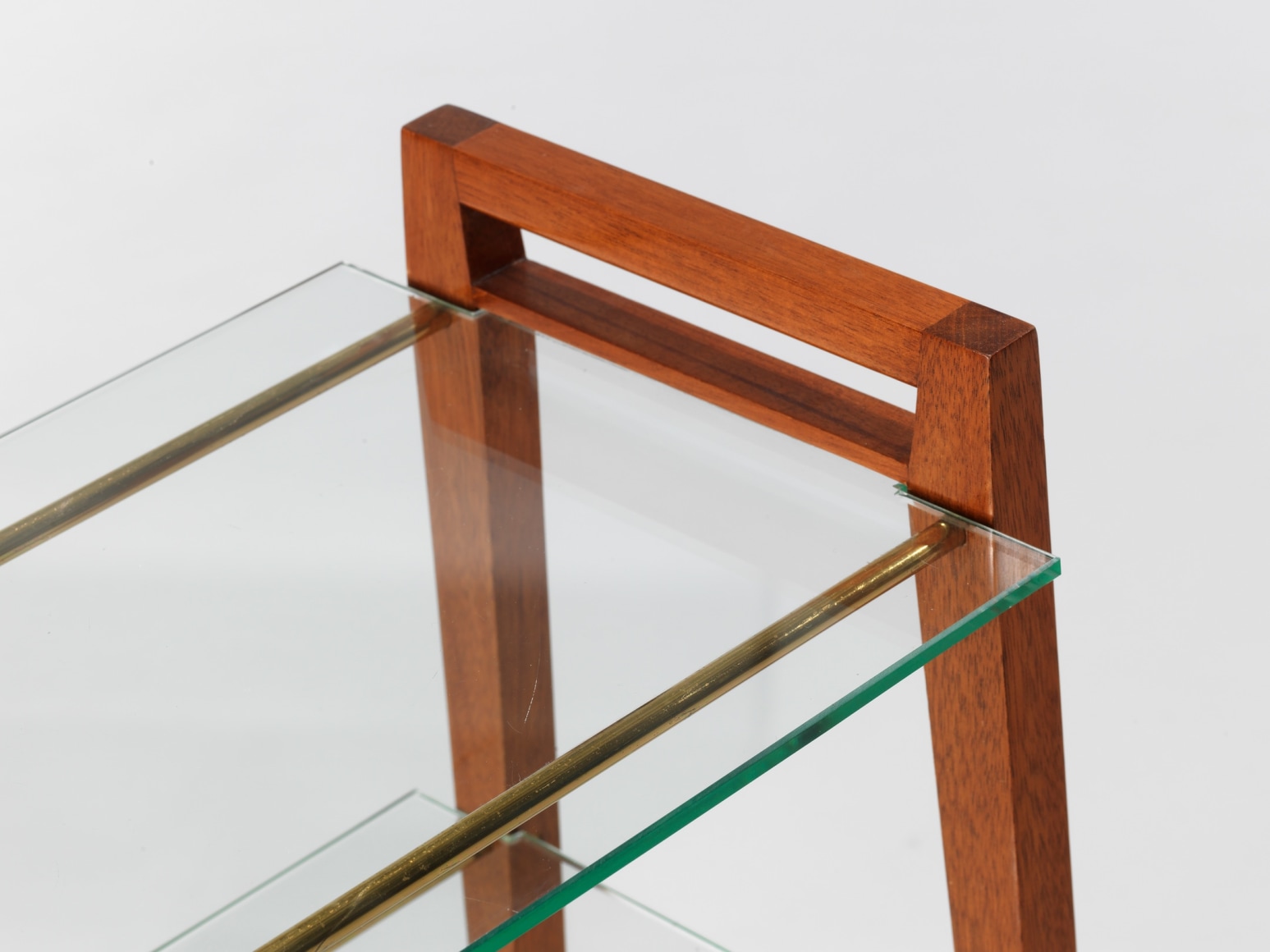 Two tier glass table with wooden legs in front of white background