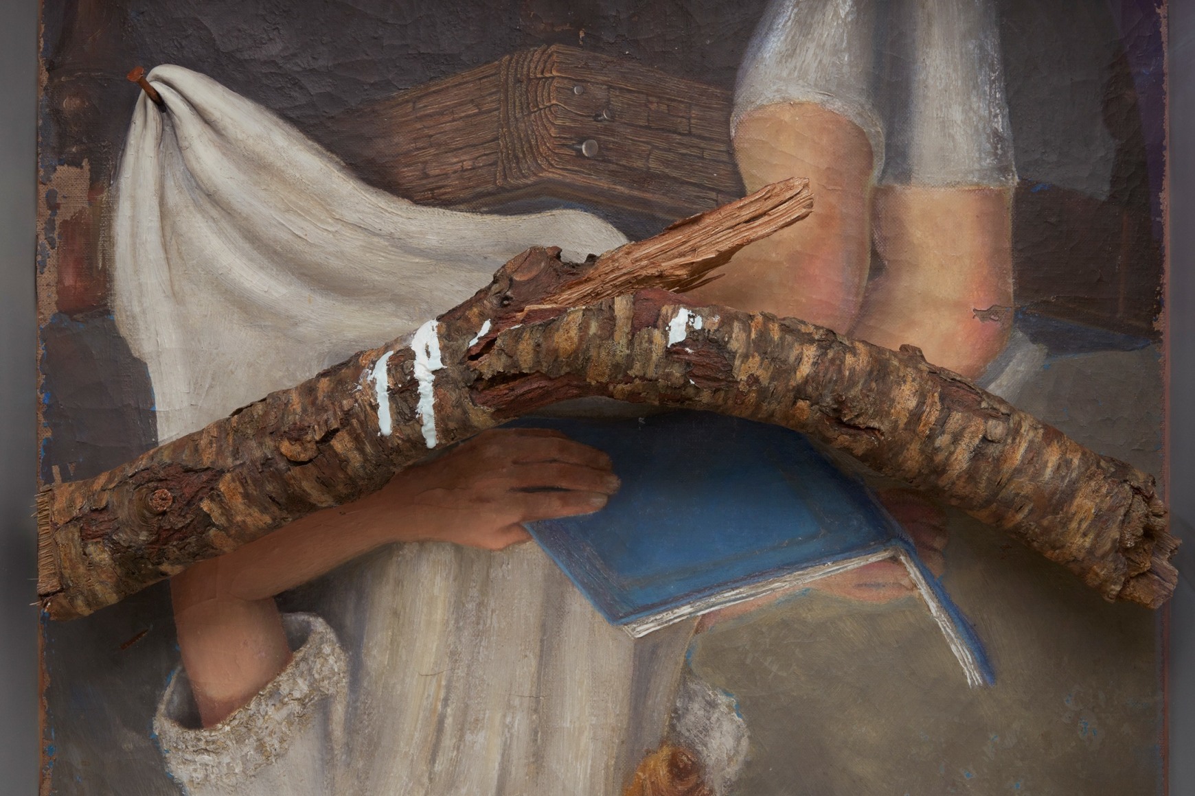 Robert Gober art work of a girl hanging upside down and reading with a branch and aluminum frame.