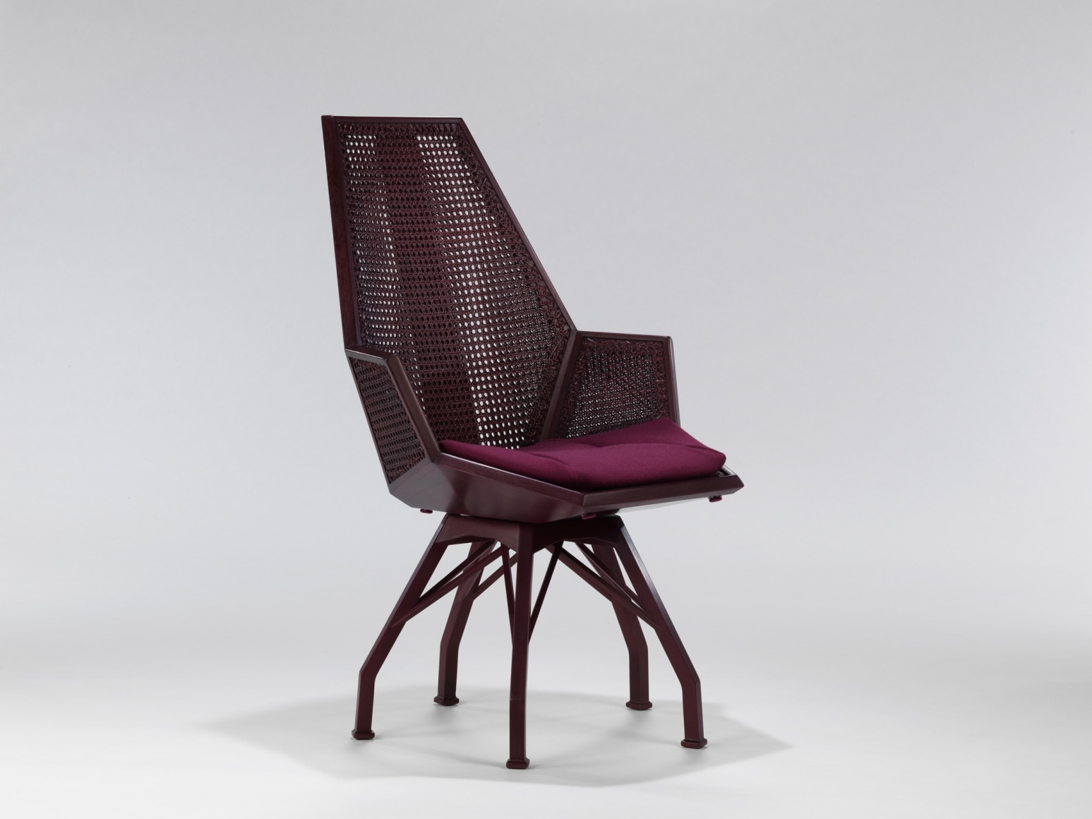 Side view of caned desk chair with red upholstered seat by Pierre Paulin