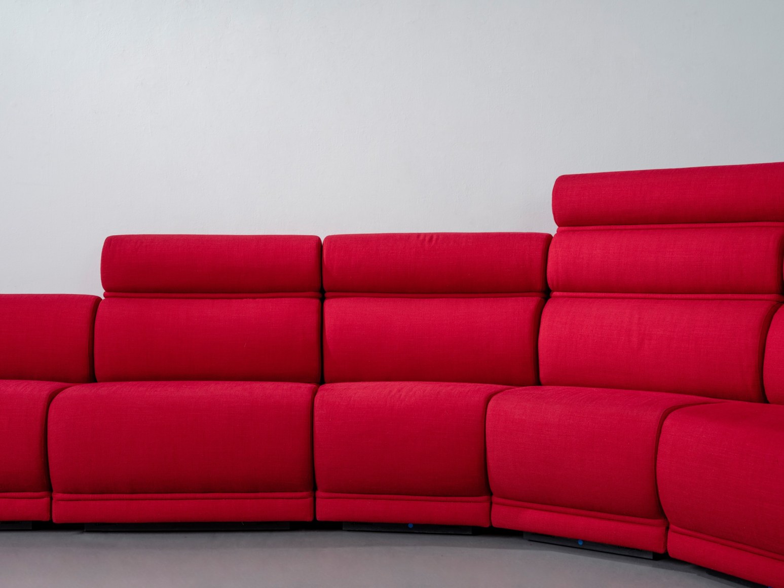 Red long huge sofa upholstered photo shots in a studio. Sofa is by Pierre Paulin.