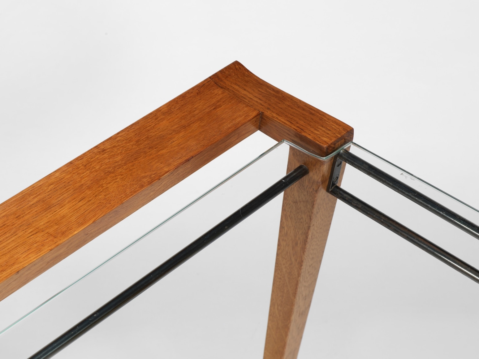 photograph of a set of three nesting tables, legs are made from wood and tops surface is glass