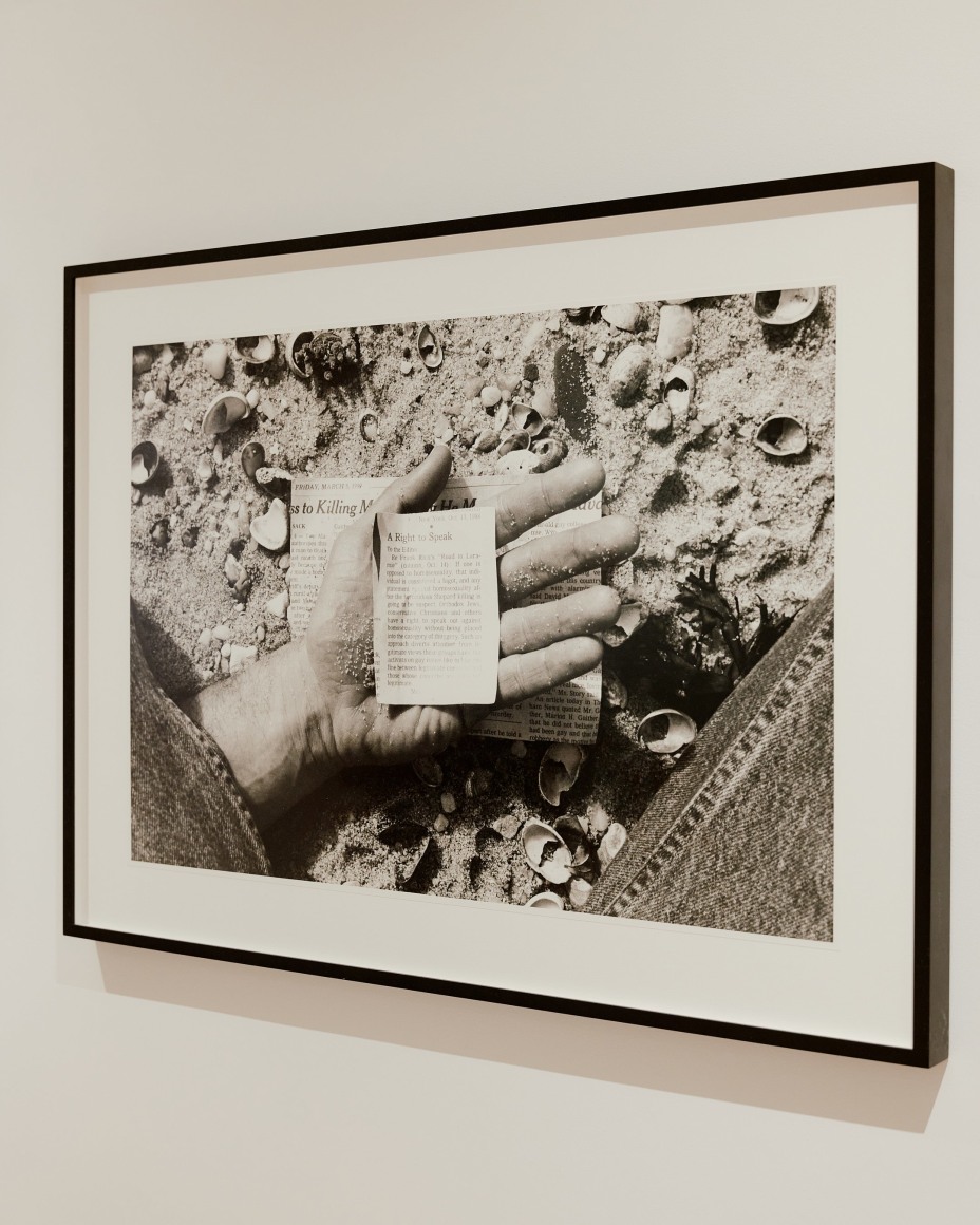 black and white photograph of newspaper clipping in a hand