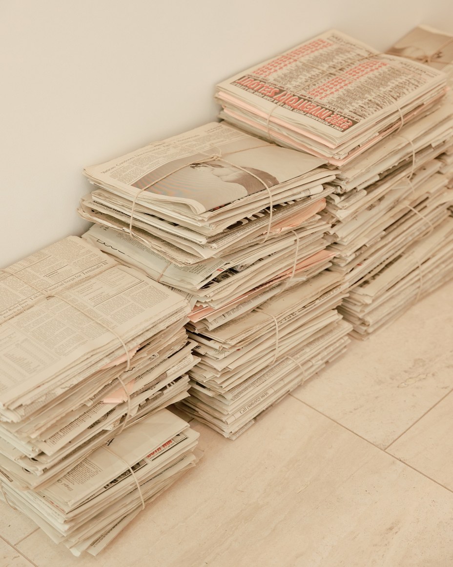 Robert Gober newspapers with various clippings and bundles in stacks.