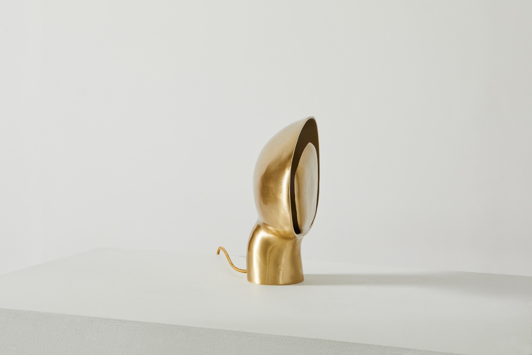 Side view of organically shaped bronze table lamp in on position
