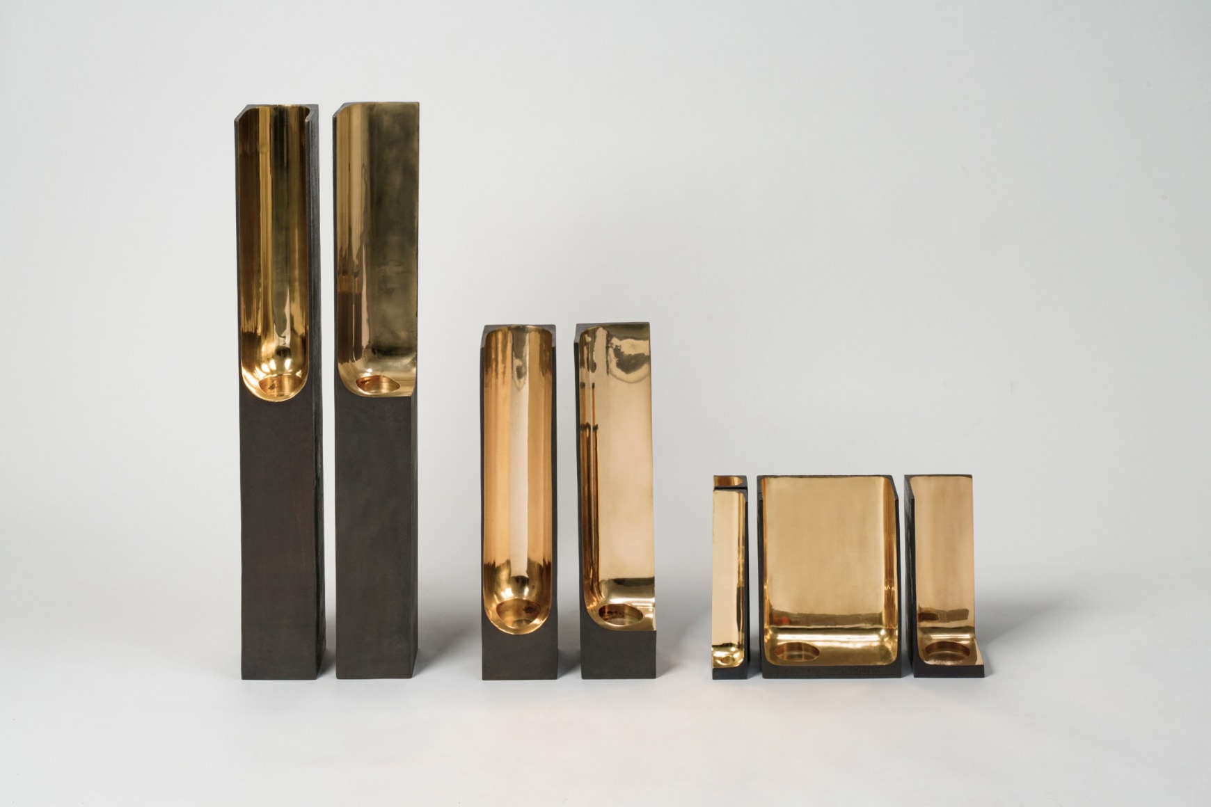 Bronze candlestick with gold detailing and black exterior.