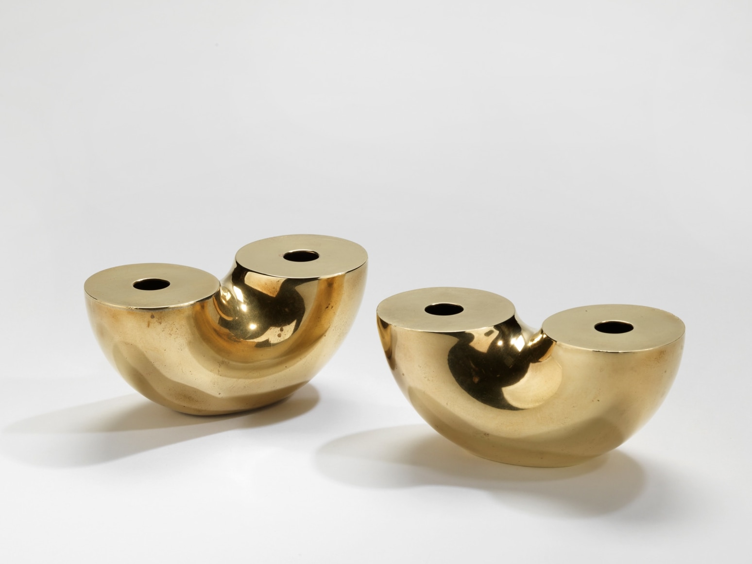 photograph of two gold vases in a blank room