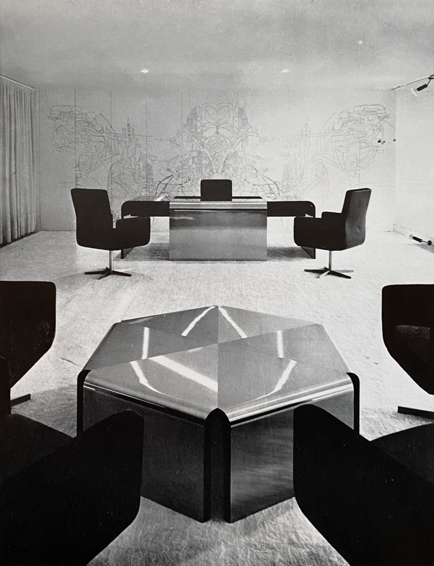 Archival image of the desk first designed and placed in a room. By Motte. Made of steel and wood.