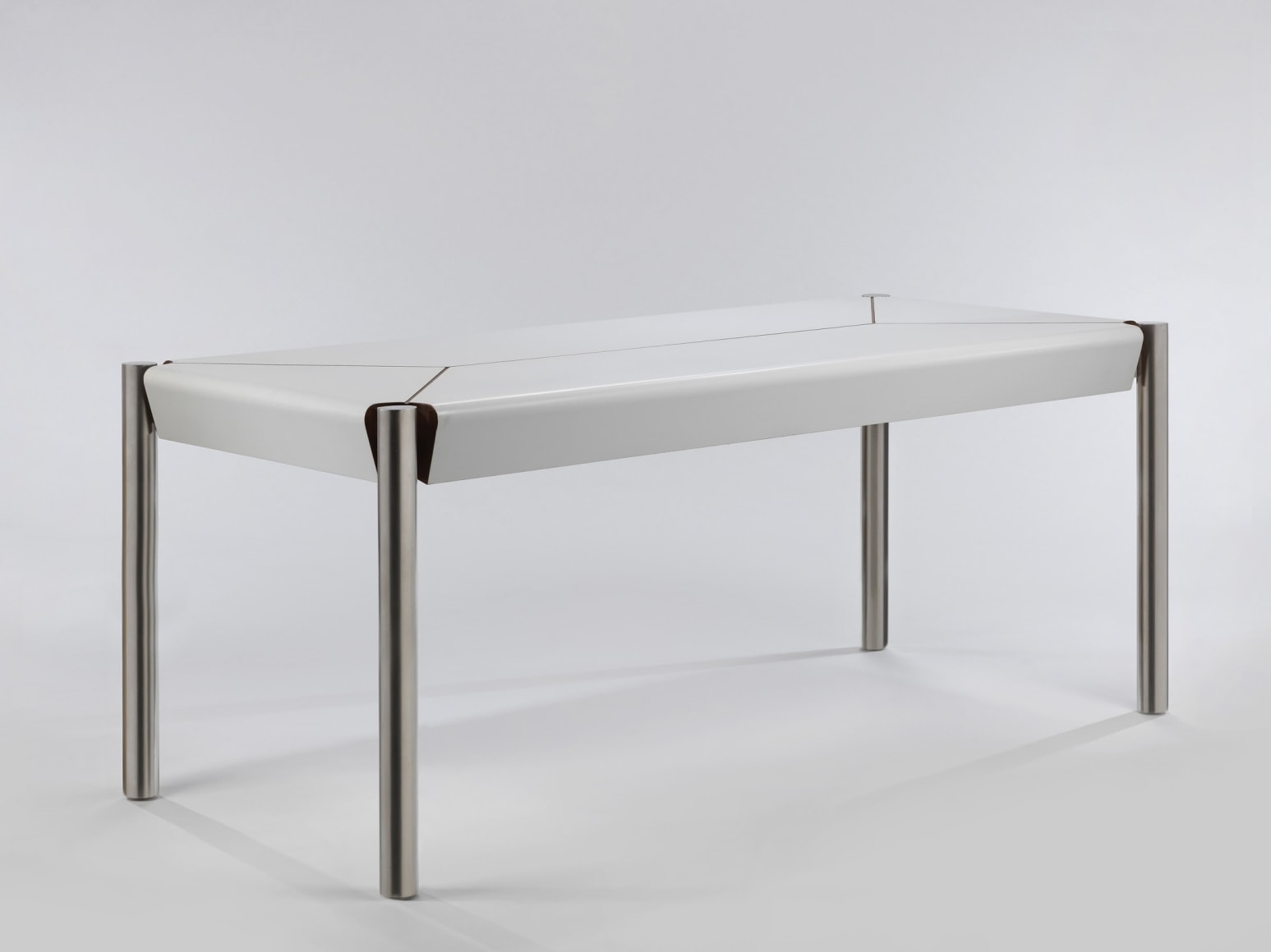 Three quarter view of white formica table with stainless steel legs
