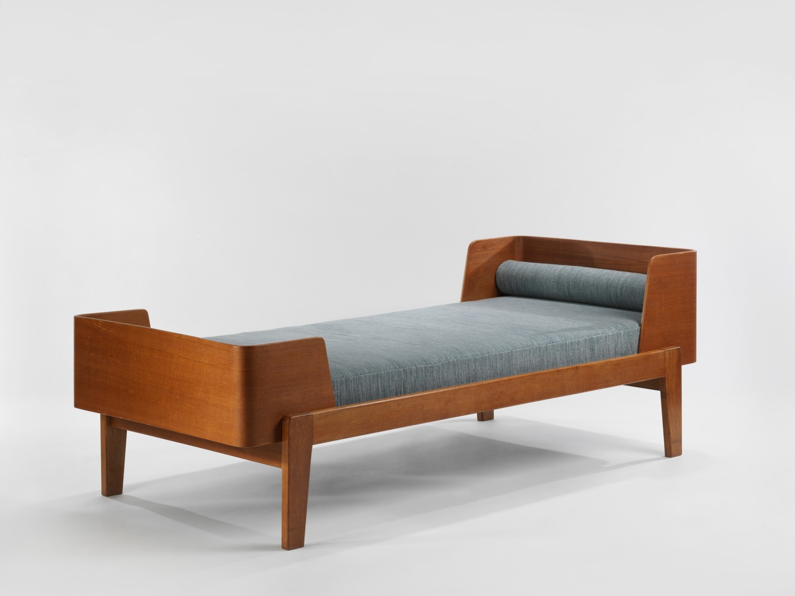 wood daybed in an empty room