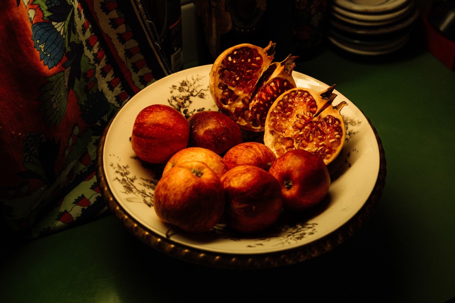 A detail of the kitchen of one of the elderly women for whom Ana Maria Jeremias works, showing a fruit basket with a pomegranate. Often considered a symbol of femininity, the pomegranate has long been associated with fertility, beauty, and the strength of women in various cultures, embodying the nurturing and life-giving qualities that are often linked to the feminine. Lisbon, Portugal, 2024