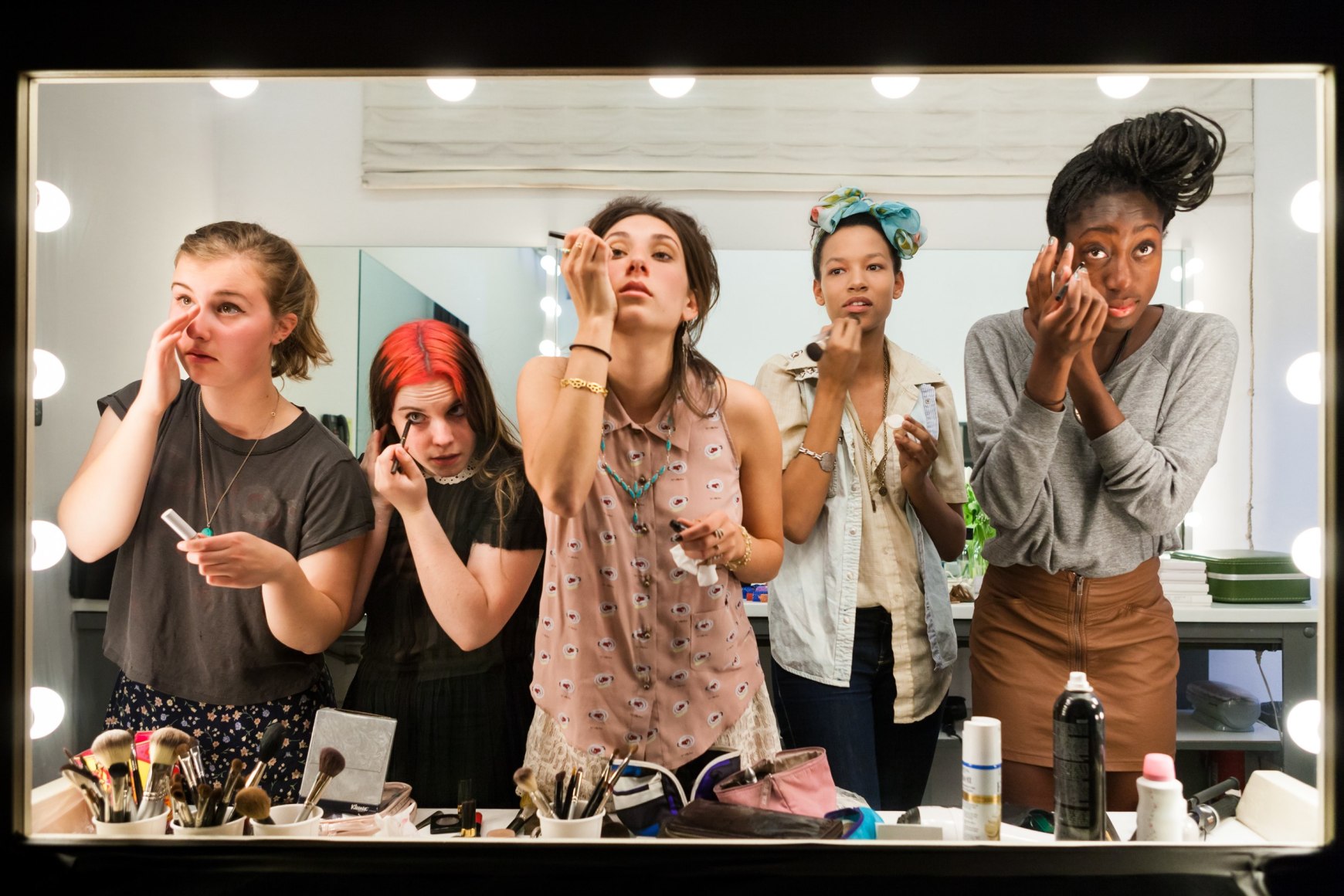 High school seniors (from left) Lili, 17, Nicole, 18, Lauren, 18, Luna, 18, and Sam, 17, put on their makeup in front of a two-way mirror for Lauren Greenfield’s Beauty CULTure documentary, Los Angeles, 2011, Archival Pigment Print