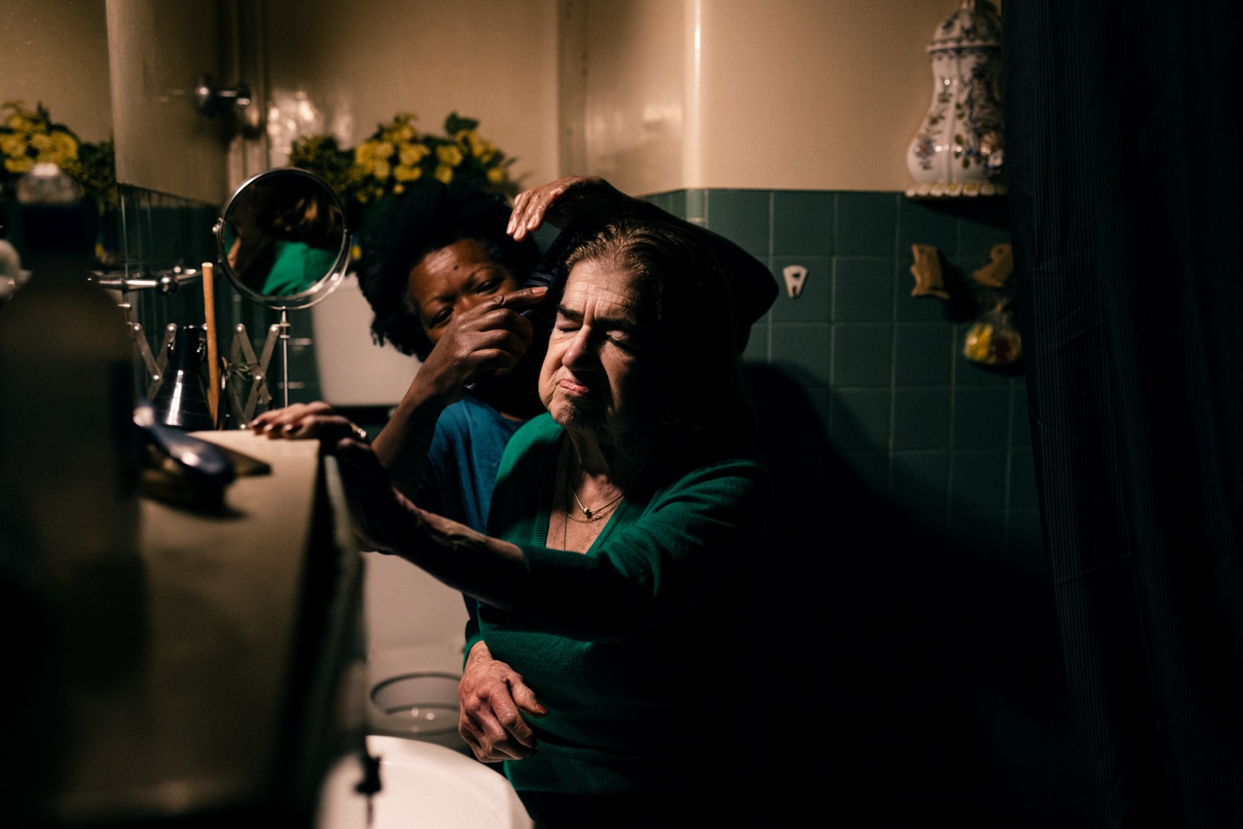 Ana Maria Jeremias cleaning and caring for the elderly lady she works for, after helping her up from a fall. Lisbon, Portugal, 2024