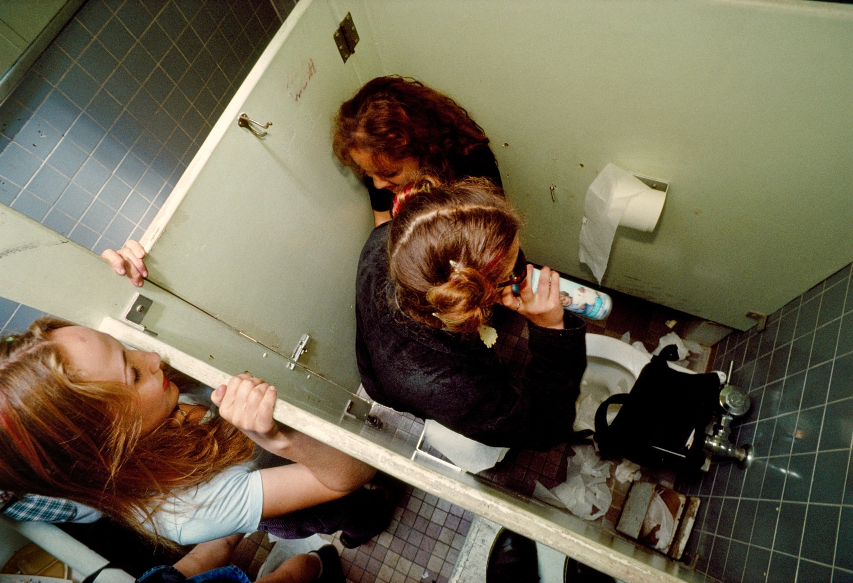 A freshman watches a sophomore inhale air freshener in the high school bathroom during nutrition break, Hollywood, Archival Pigment Print