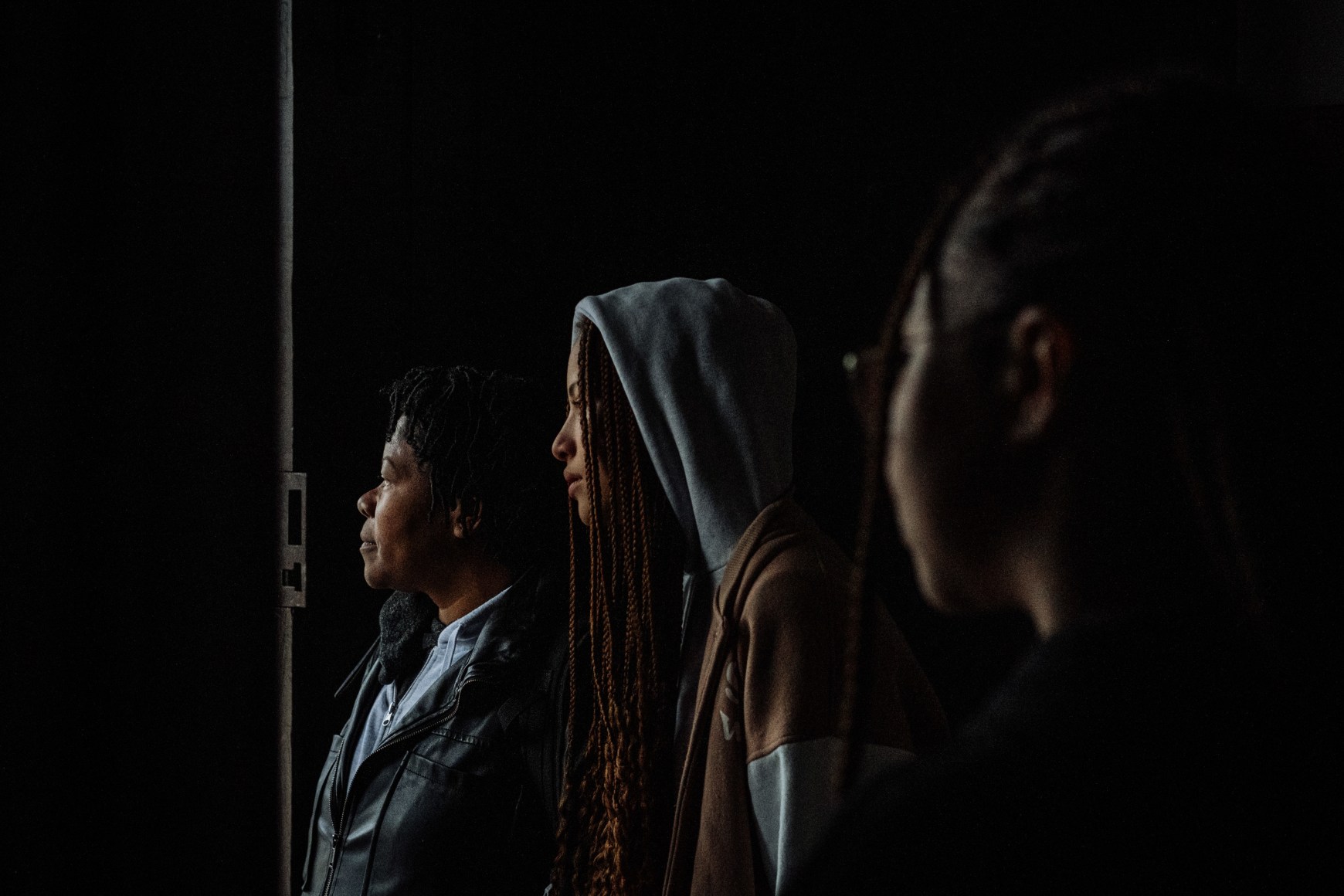 Ana Maria Jeremias on the weekend, traveling 755 km to visit her granddaughters, Leonor and Beatriz, who live with her mother far from Lisbon. In the photo, they are waiting for the rain to stop after mass, at the entrance of Igreja Nova de Sao Jose. Fafe, Portugal, 2024