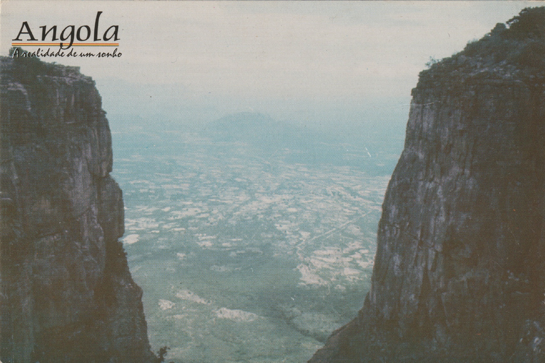 A postcard Ana Maria Jeremias kept from an Angolan mountain landscape, where the phrase 'Angola: The Reality of a Dream' can be read, 2024
