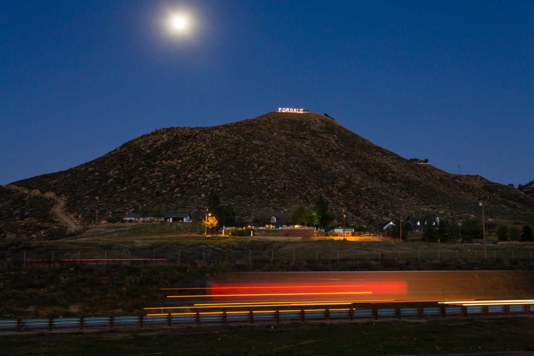 “FOR SALE” is written in Christmas lights on a bluff above I-15 in Southern California’s troubled Inland Empire, where real estate values plummeted, 2009, Archival Pigment Print