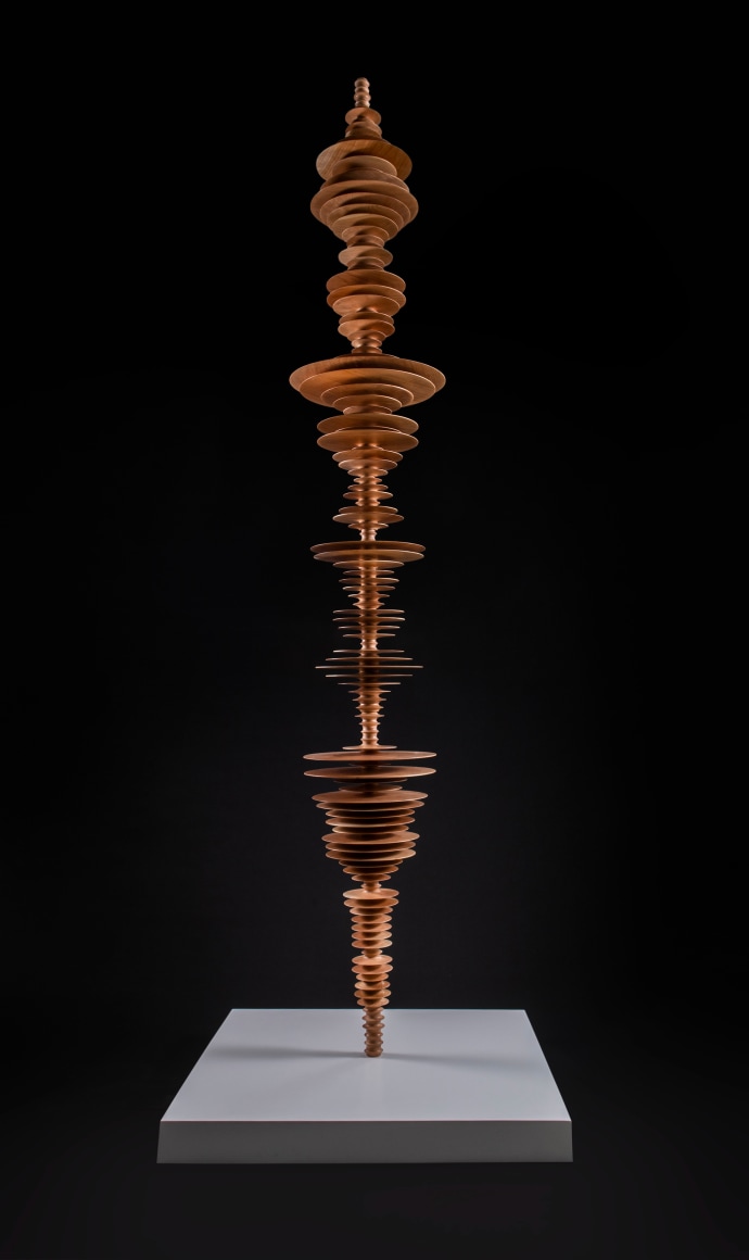 a sculpture by Elizabeth Turk of wood discs layered and arranged to resemble a Modernist abstraction and a sound wave