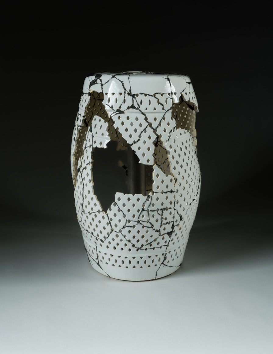 a broken ceramic stool which has been glued back together with black epoxy by Maria Elena Gonzalez