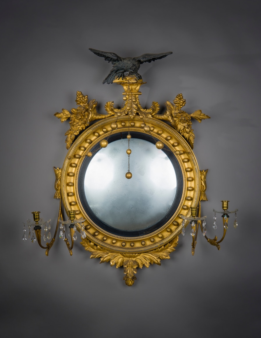 "Neo-Classical Convex Girandole Mirror with Candle Arms," about 1810. American, probably Salem, Massachusetts. Eastern White Pine (Pinus strobus), gessoed and gilded, and partially ebonized, with convex mirror plate, glass drip pans, blown and cut, glass prisms, gilt-brass candle cups and bobeches, and brass chain 43 in. high, 38 in. wide, 10 5/8 in. deep