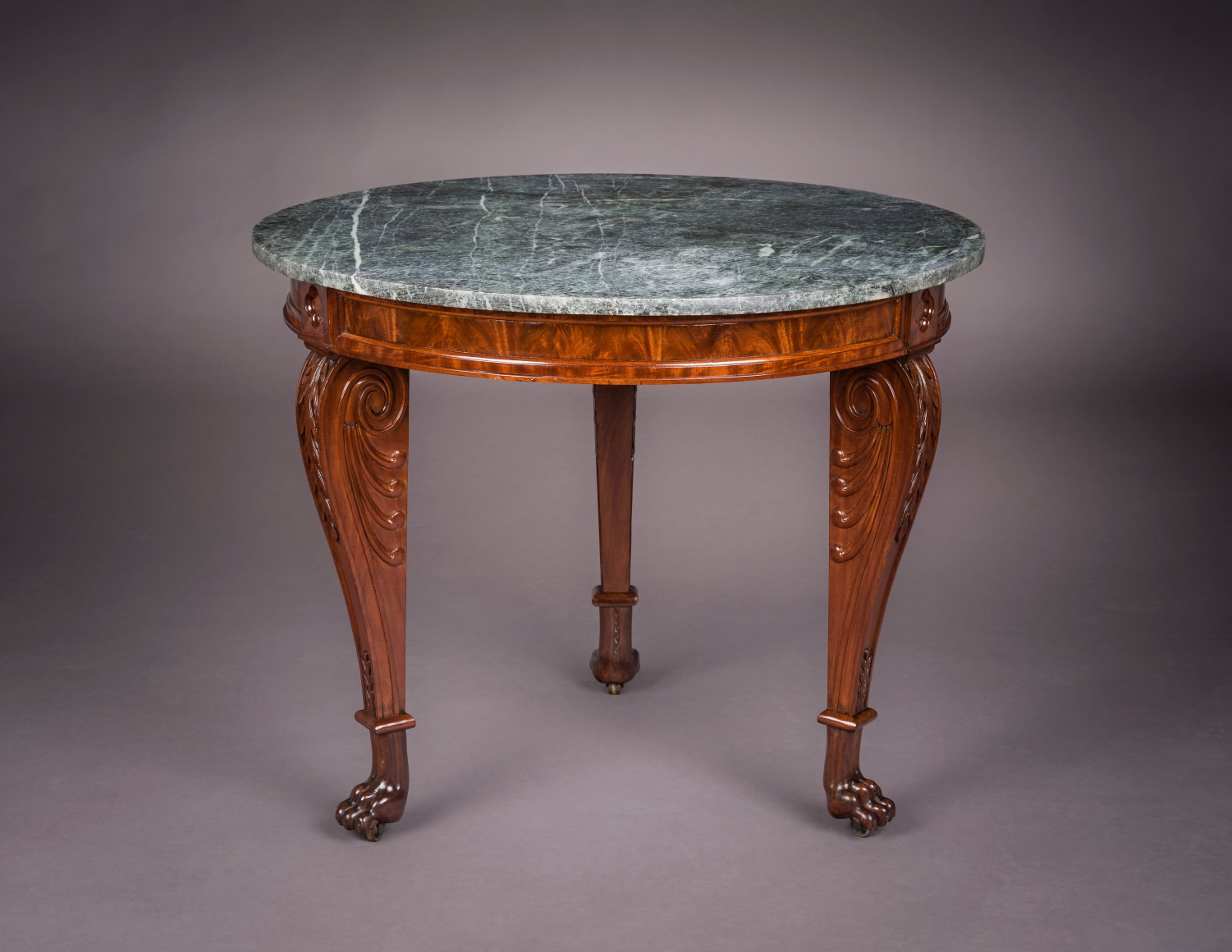 Center Table, about 1818&ndash;20 Attributed to Thomas Seymour (1771&ndash;1848), working either for James Barker or for Isaac Vose &amp; Son, with Thomas Wightman (1759&ndash;1827) as carver, Boston. Mahogany, with brass castors and green marble top 29 3/4 in. high, 36 in. diameter.