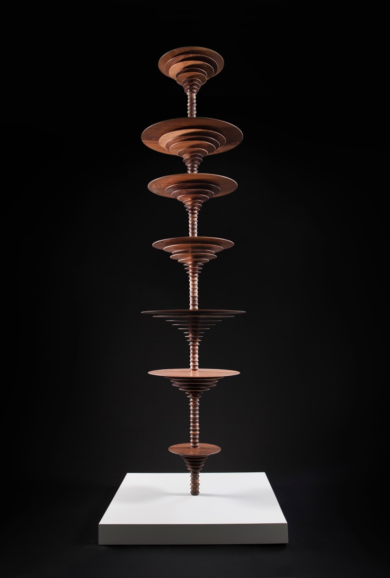 a sculpture by Elizabeth Turk of wood discs layered and arranged to resemble a sound wave and a modernist abstraction