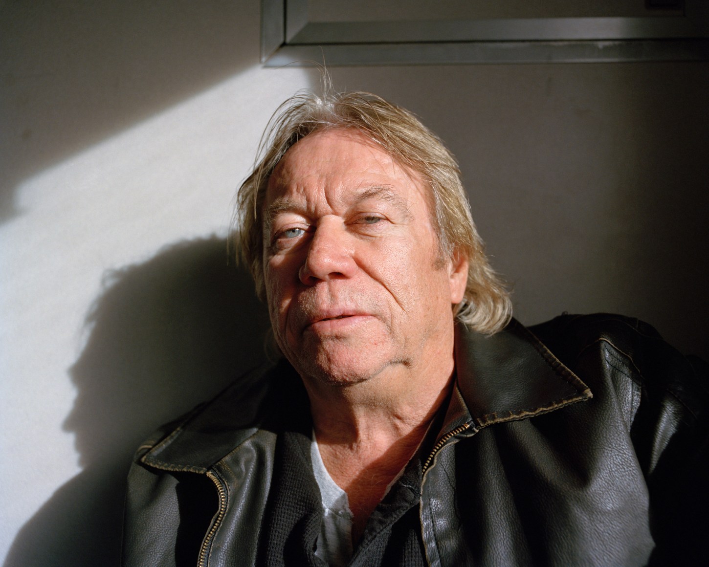Headshot of person in sun on a train, by McNair Evans