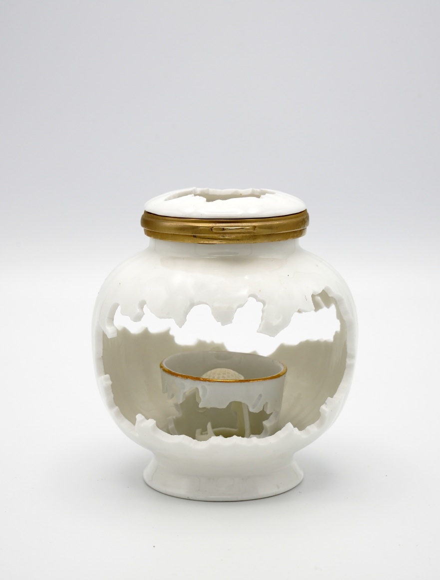 White porcelain lidded jar with hand cut patterns