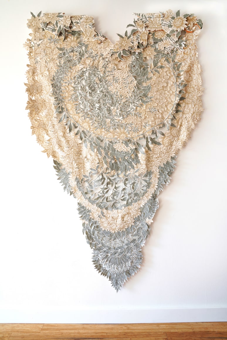 A floral wall hanging made of a curtain with cut cut patterns