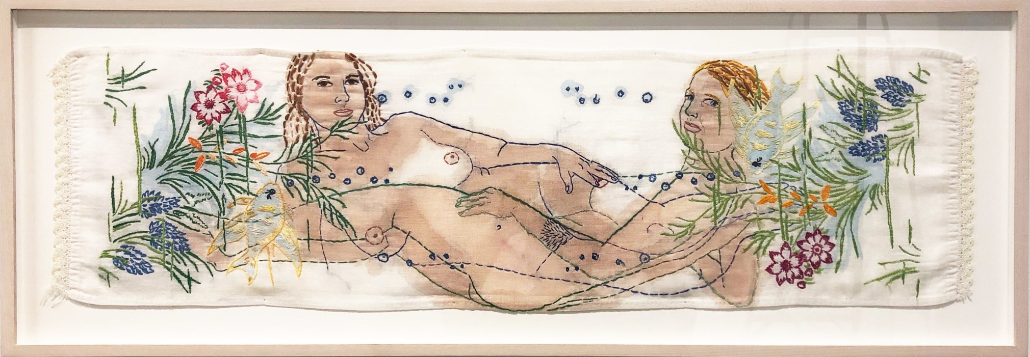 two nude women reclining in opposite directions with a embroidered flower border