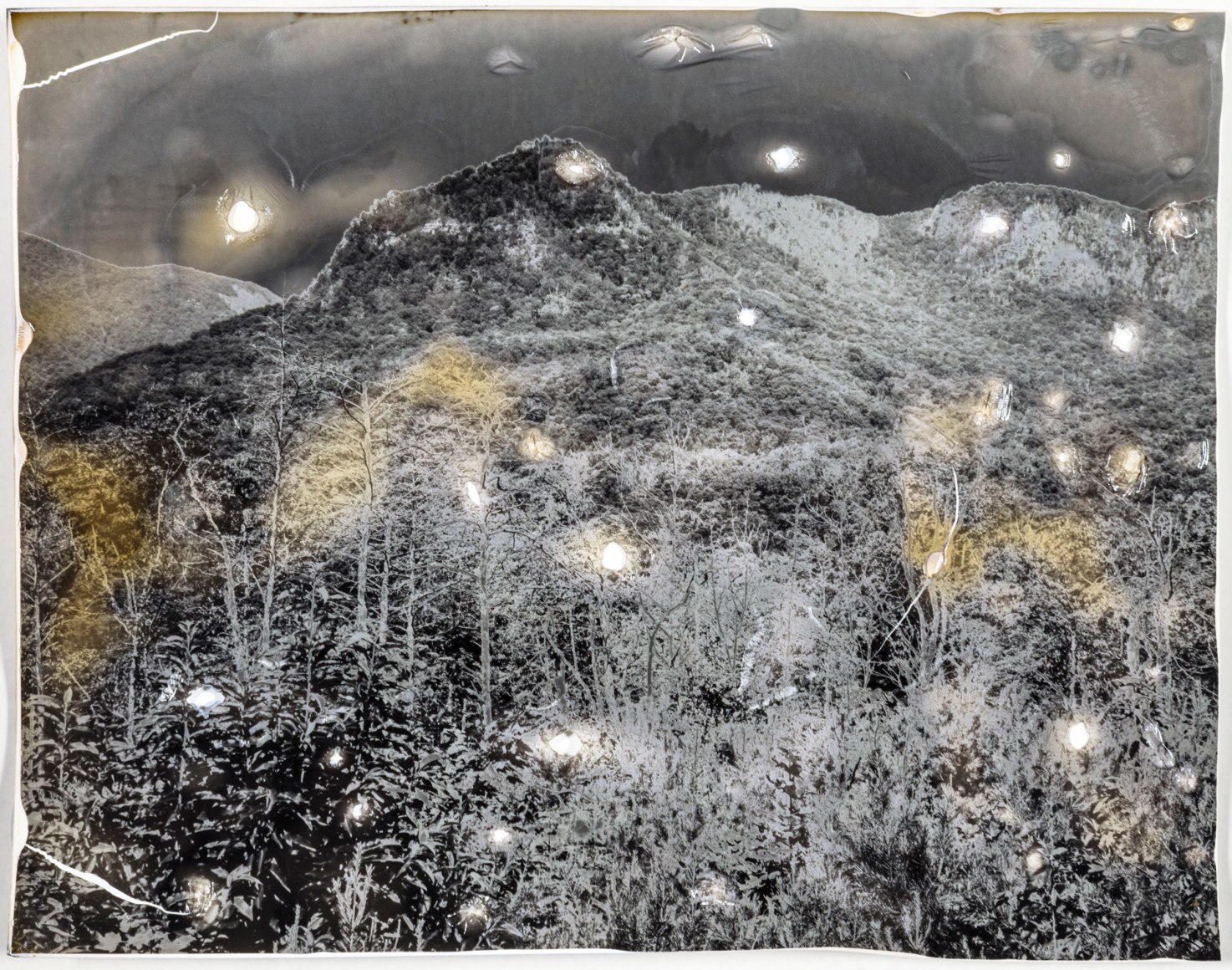 Gesche Würfel  Rumbling Bald, NC (1), version 1, 2020-2021  Solarized and roasted gelatin silver print on glossy RC paper  8h x 10w in 20.32h x 25.40w cm  GW_016, Black and White, Landscape, Solarized to create an eerie atmosphere through reversed tones with hints of yellow to emulate a light effect