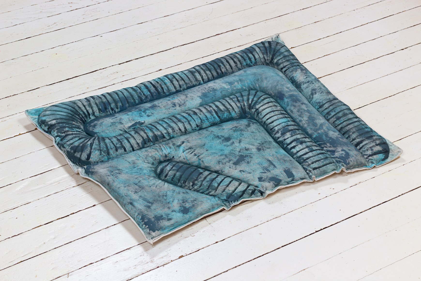 Susan Metrican  Night Crawler, 2020  acrylic on cotton, canvas, recycled cotton, thread  22h x 29w in 55.88h x 73.66w cm  SM_005, blue floor cushion with the painted and fabric pattern of earth worms