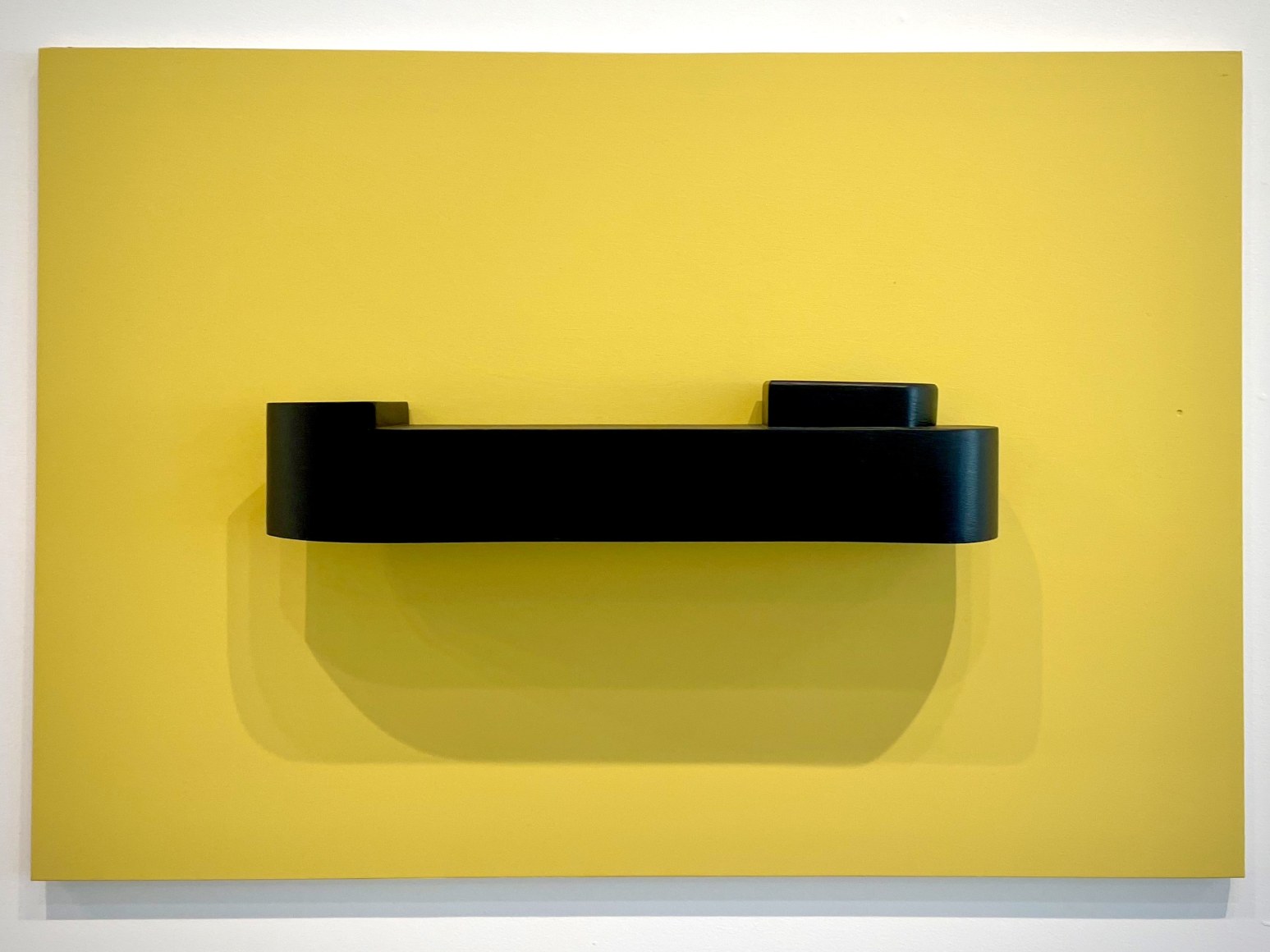 Wooden boat wall sculpture on yellow board