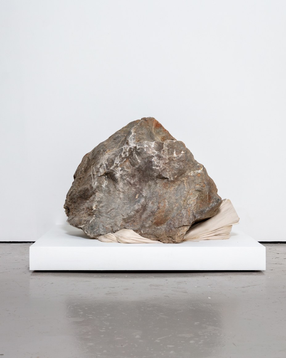 Large bolder on top of folded mattress, by Randy Shull