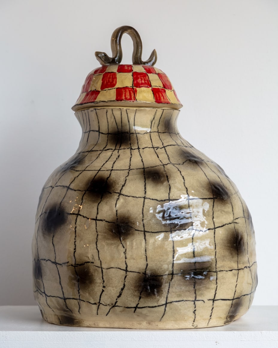 gourd shaped hand coiled vessel with lid. Underglaze has black dots and black crosshatching, the lid is red with a blue handle