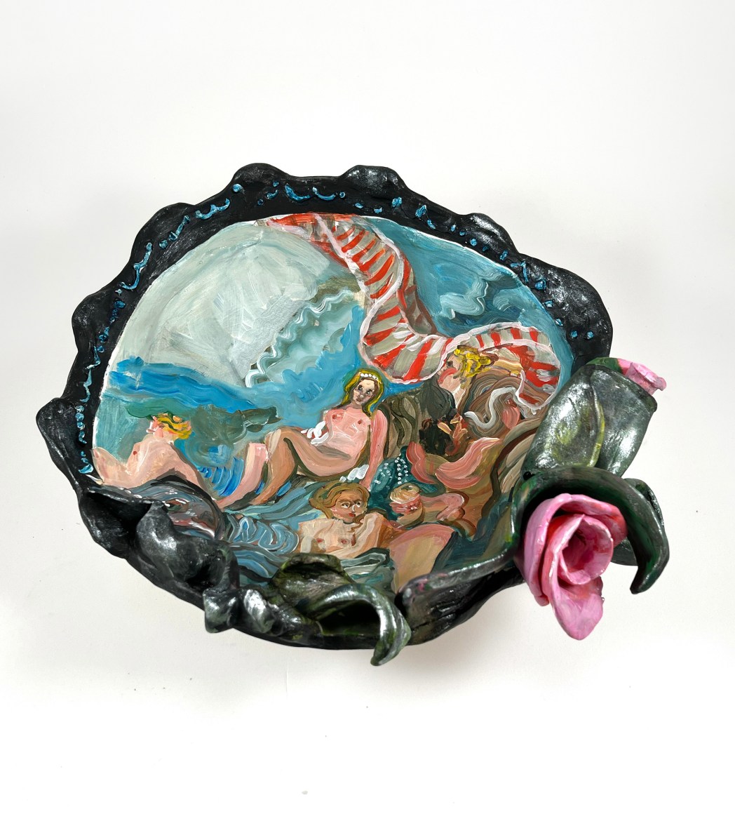 black porcelain platter with several nude females lounging near the water