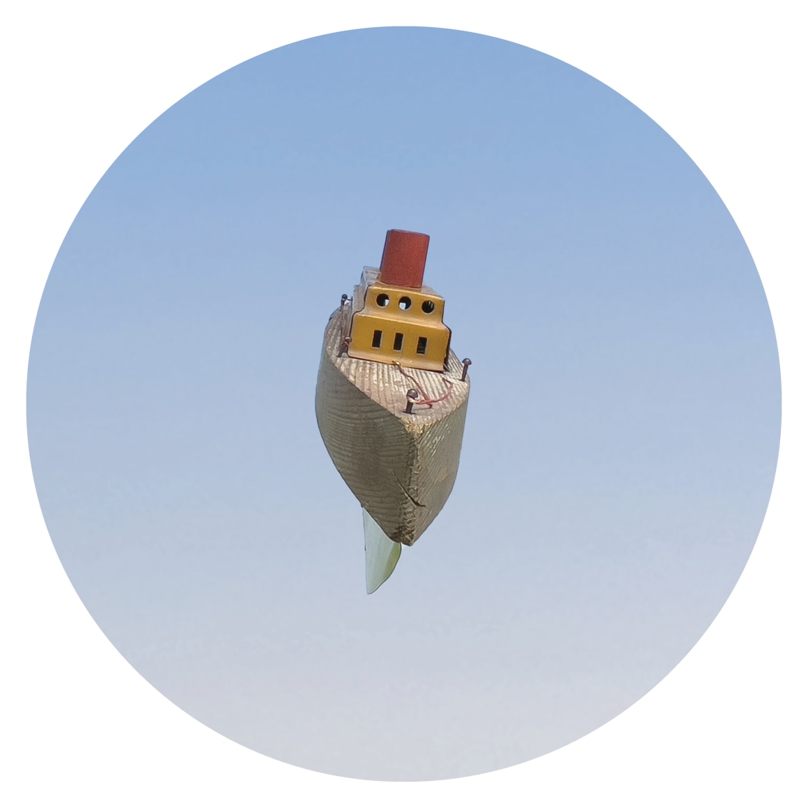 Circular image of toy boat on blue background, by Workingman Collective