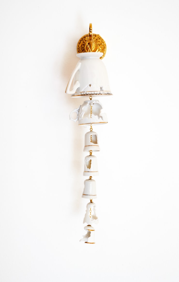 Wall hanging of hand cut porcelain teacups and bells with brass fixture and gold chain
