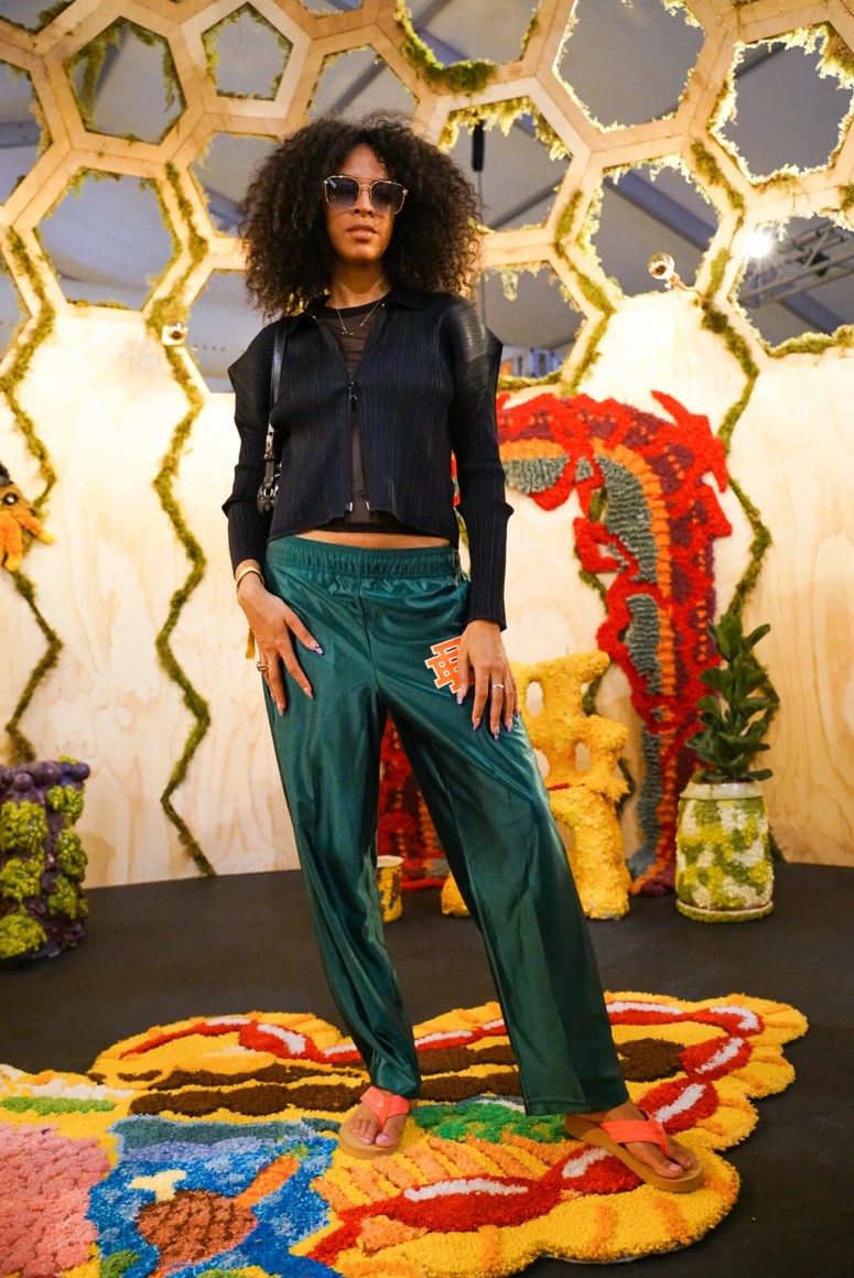 A visitor to the booth stands inside of Rem Denizen&#039;s Pleroma Dome (2021, inquire for details and pricing) surrounded by textiles and ceramic furniture by Nick Weddell (inquire for details &amp;amp; pricing).