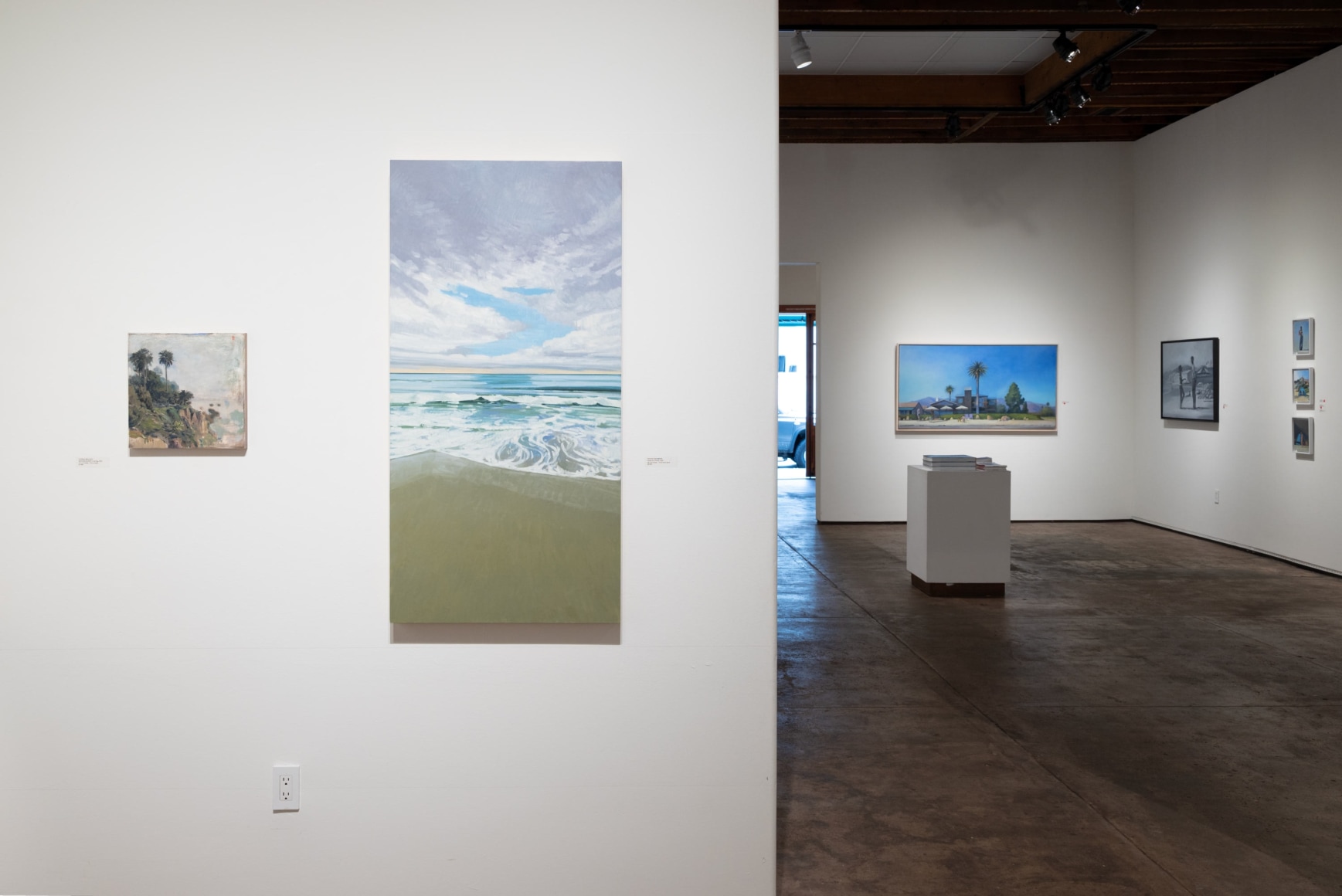 Installation photograph of The Spring Salon, 2025 with Nathan Mellott, Nicole Strasburg with Hank Pitcher in the background