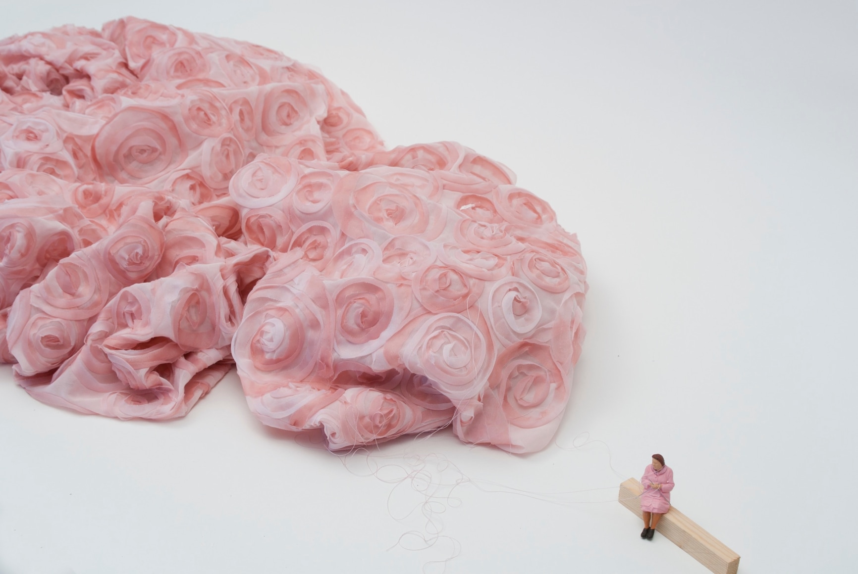 Liliana Porter, Tejedora, 2017. Fabric, figurine, string on wooden base, 22 1/2 x 96 1/2 x 90 in., (57.2 x 245.1 x 228.6 cm.)