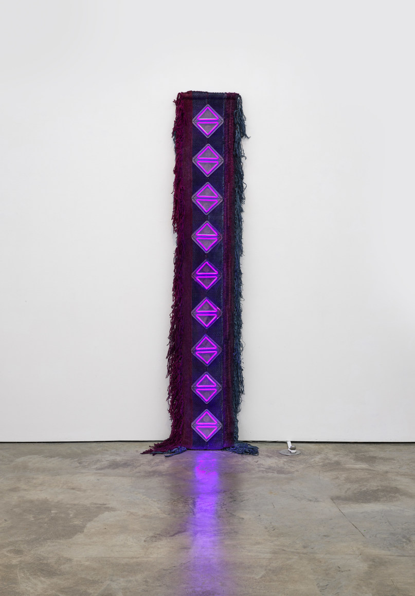 Sandra Monterroso, Como la serpiente, la cochinilla y la indig&oacute;fera nos devuelven la luz. [Like the serpent: the cochineal and the indigofera give us back the light], 2023.&nbsp;Wool rug dyed with cochineal, cotton cloth dyed with indigo, acrylic, neon,&nbsp;97 1/4 x 20 1/2 x 1 3/4 in.&nbsp;