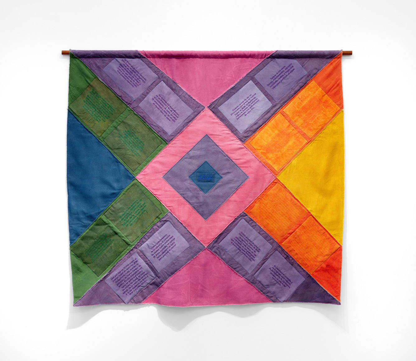 Sandra Monterroso, Rombo para sanar heridas [Diamond to heal wounds], 2022. Linen and cotton dyed with natural dyes: cochineal, indig&oacute;fera, turmeric, annatto and synthetic dyes. Embroidered and sewn letters on the textile. Thread synthetic. 55 7/8 x 61 3/4 in. (142 x 157 cm.)