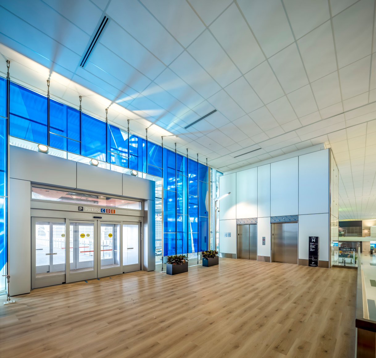 Marta Chilindron, Unexpected Spaces, 2025. Digital print on glass and polished stainless steel, 21&rsquo; x 20&rsquo; (yellow), 21&rsquo; x 35&rsquo; (green), 15&rsquo; x 27&rsquo; 6&rdquo; (blue). Permanent installation at George Bush Intercontinental Airport (IAH), Terminal E. Image courtesy of Houston Airports. Photos by Slyworks.