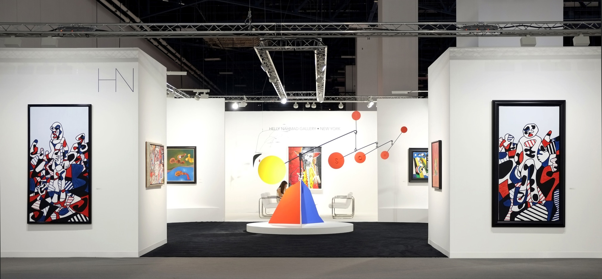 Installation view of Art Basel | Miami Beach 2017, booth A4. This photo features the front of the booth. The left wall of the booth features a painting by Jean Dubuffet called &quot;Promenade Agreste&quot; it was made in 1974, the materials are acrylics on canvas, the size is 77 x 39.5 inches or 195.6 x 100.3 centimeters. In the middle of the booth is featured a sculpture by Alexander Calder. It's a standing mobile called, Untitled, made in 1955, the size is 108 x 142 x 59 inches or 276 x 362 x 150 centimeters. The wall on the right features a painting by Jean Dubuffet called, Site au Promeneur, made in 1974, the size is 74 x 39 inches or 190 x 100 centimeters. Photography by Studio MDA.  &copy; 2018 Calder Foundation, New York / Artist Right Society (ARS), New York. &copy;Helly Nahmad Gallery NY.