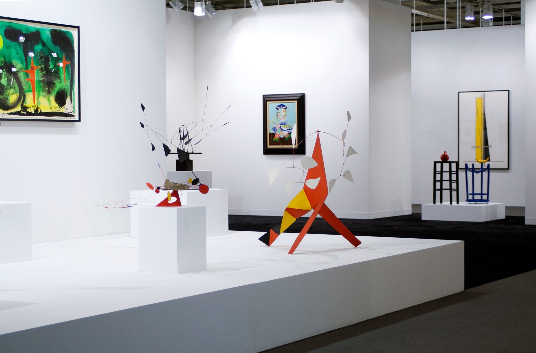 Installation view of Art Basel | Basel 2014, booth A8, featuring four sculptures and two paintings and one watercolor. The watercolor is by Alexander Calder and is called, Untitled, made in 1953, watercolor on paper 73.66 x 107.95 centimeters or (29 x 42.5 inches.). The painting in the middle of the photo is by Pablo Picasso and is called, La fille de l&rsquo;artiste &agrave; deux ans et demi avec un bateau, (The daughter of the artist at two years old holding a boat) it was made in 1938, Oil on canvas 73 x 54 centimeters. (28 3/4 x 21 1/4 inches.) There is three standing mobile by Alexander Calder in the middle of the photo, two of them rest on pedestals while one stands directly on the ground on its three legs. The first standing mobile is called, The Amoeba, it was made in 1974, it is made of painted sheet metal, wire and brass, the size is 27.3 x 60.9 x 60.9 centimeters or (103&frasl;4 x 24 in. x 24 inches.) The second mobile by Alexander Calder is called Five White against Five White and was made in 1973 it s made of painted metal and wire standing mobile 104.1 x 121.9 x 73.7 cm. (41 x 48 in. x 29 in.),on the right of the photo there is a sculpture by Joan Miro, called&quot; Homme et Femme dans la Nuit&quot;, 1969 Sculpture: Painted bronze 86.5 x 72 x 50 cm. (34 x 28 1/3 in. x 19 in.)&copy; 2018 Calder Foundation, New York / Artist Right Society (ARS), New York. &copy;Helly Nahmad Gallery NY